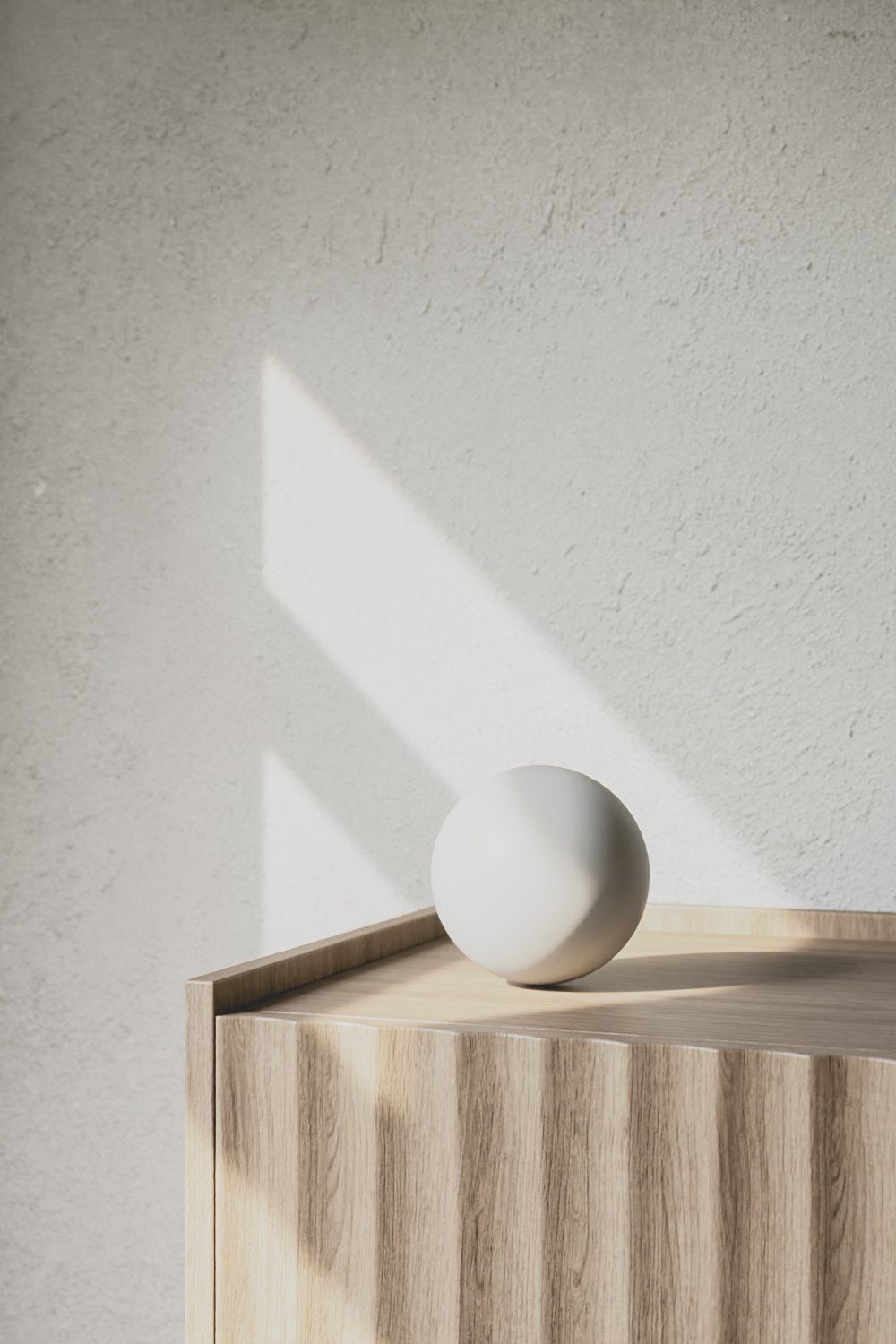 Eine weiße Kugel liegt auf einem Sideboard.